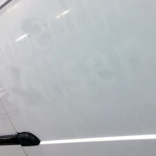Autobelettering nog zichtbaar in de autolak