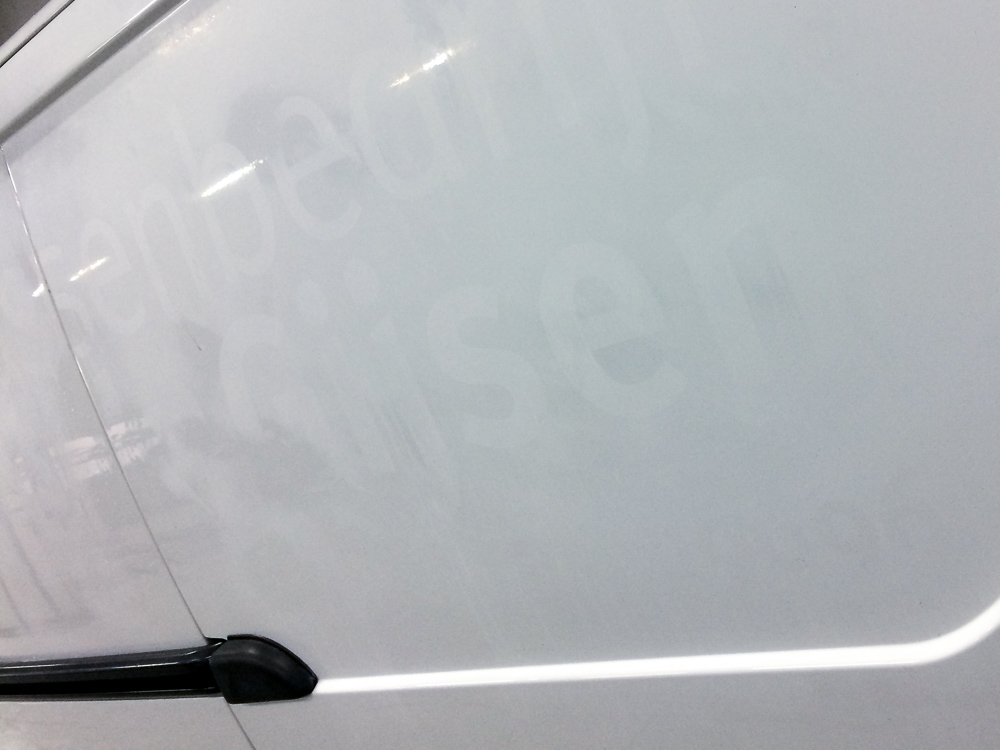 Spooklogo in de autolak Autobelettering nog zichtbaar in de autolak